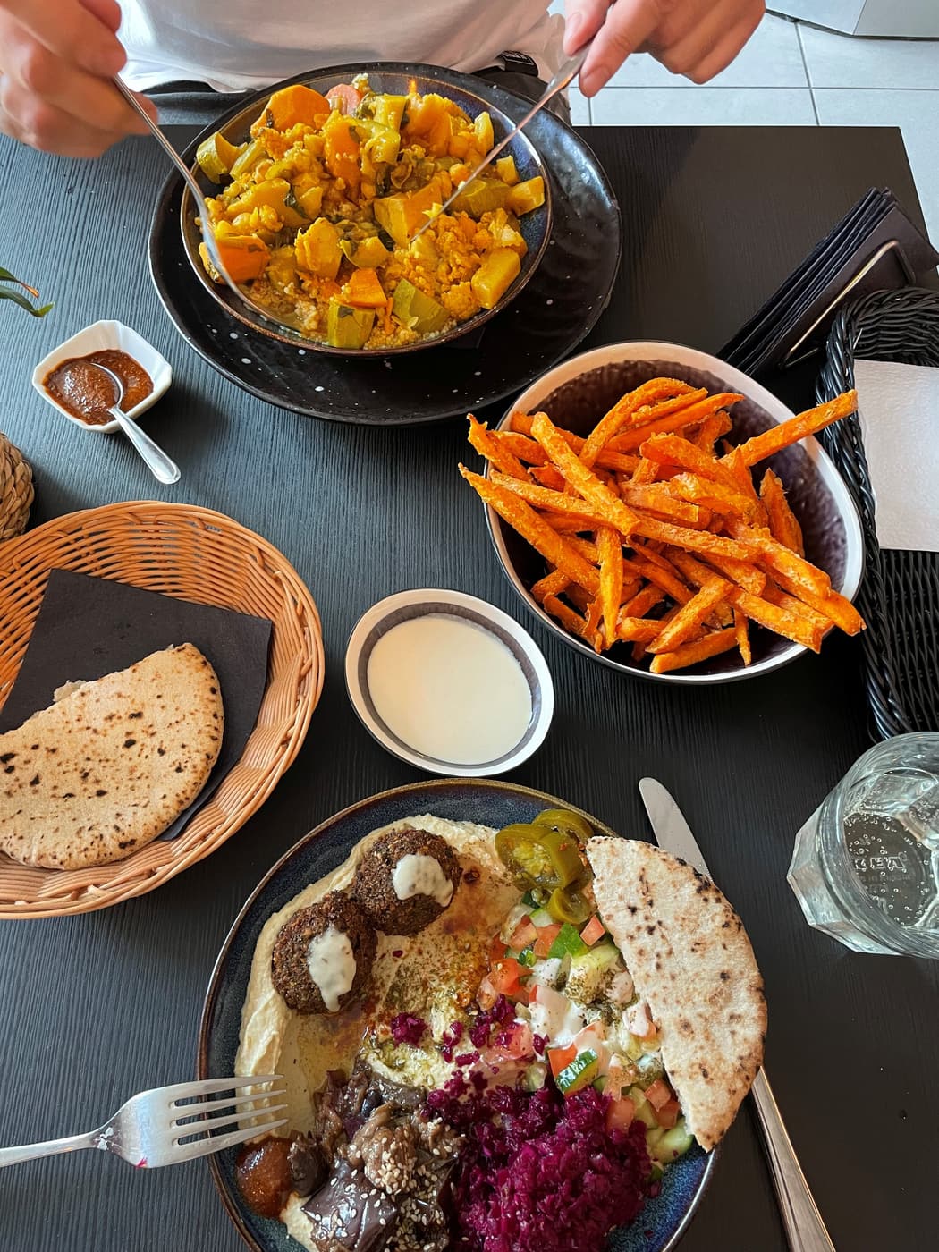 An Israeli spread of falafel, hummus and pita with sweet potato fries at a Riga restaurant